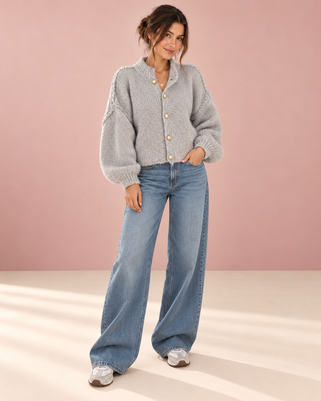 Anker Strickjacke am Model vor roséfarbenem Hintergrund