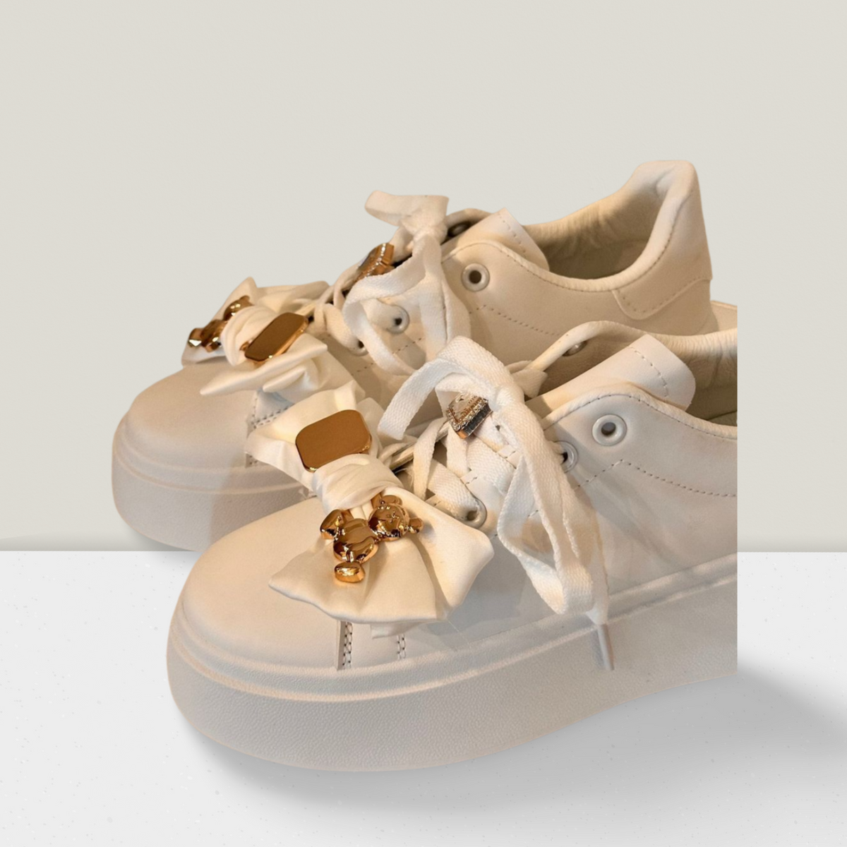 Sneakers mit Schleife und goldenen Details